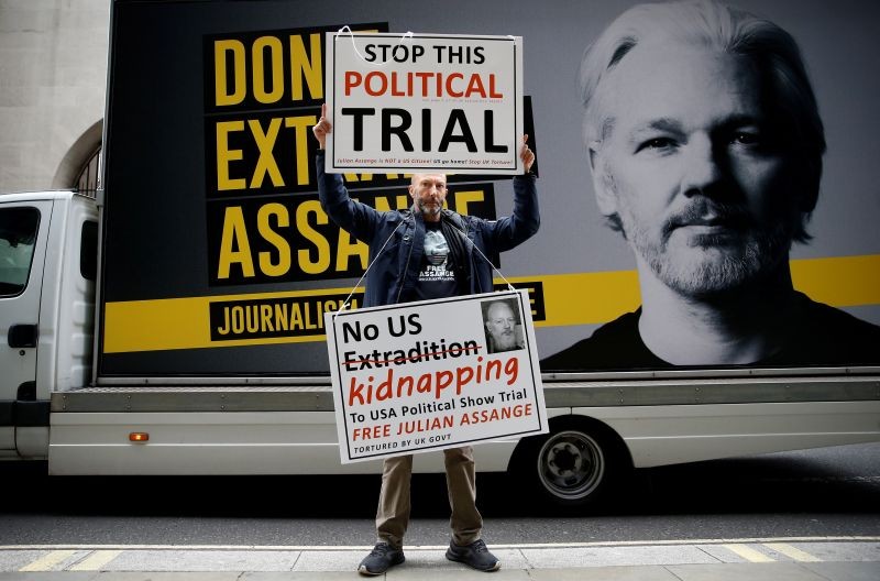 A protestor holds signs outside the Old Bailey, the Central Criminal Court ahead of a hearing to decide whether Assange should be extradited to the United States, in London, Britain on September 8, 2020. (REUTERS Photo)