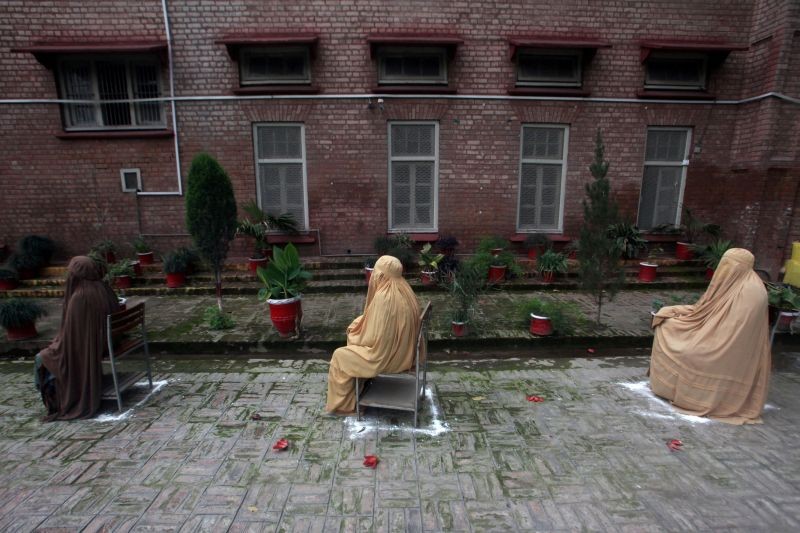 Women, clad in burqa, sit on chairs maintaining safe distance, as they wait for their turn to receive cash from a counter of Ehsaas Emergency Cash program, introduced by the government for vulnerable families due to the spread coronavirus disease (COVID-19), in Peshawar, Pakistan on April 9, 2020. (REUTERS File Photo)