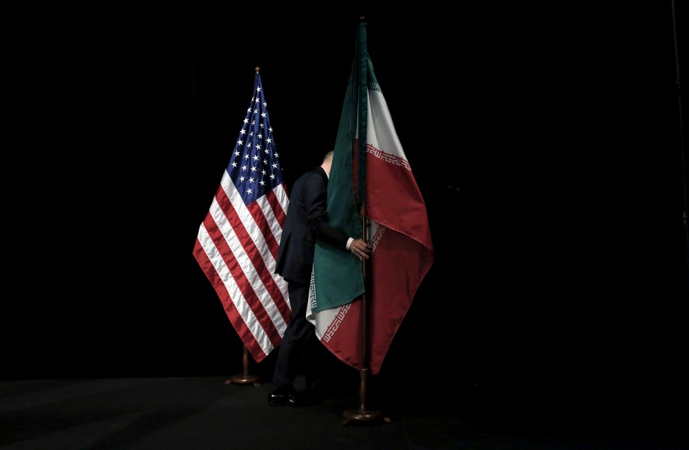 FILE PHOTO: A staff member removes the Iranian flag from the stage at the Vienna International Center in Vienna, Austria July 14, 2015. REUTERS/Carlos Barria