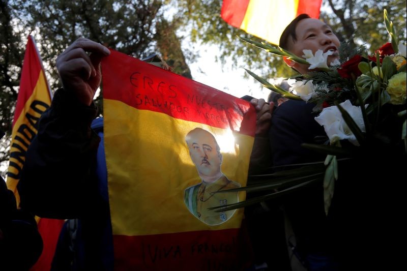 A supporter of late Spanish dictator Francisco Franco holds a flag with his portrait outside Mingorrubio-El Pardo cemetery after the reburial of his remains, in Madrid, Spain on October 24, 2019. Words in the flag read "You are our hero, saviour and pride. Long live Franco!". (REUTERS File Photo)