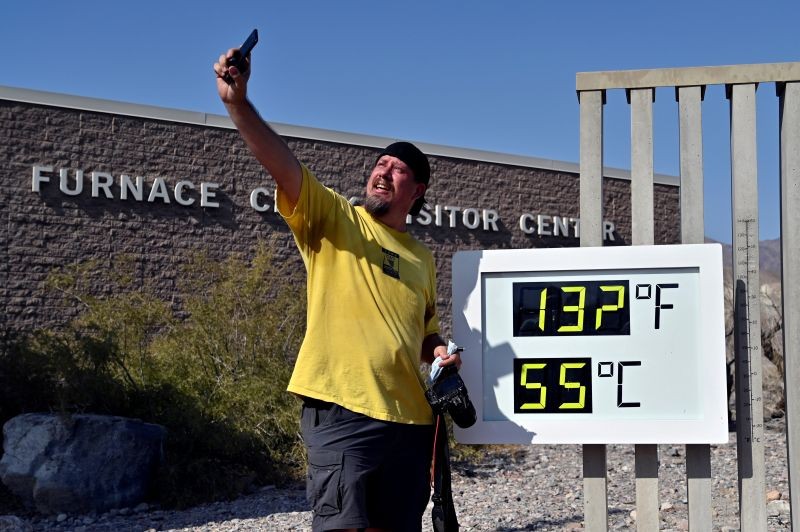 Greg Berndt takes a selfie with the thermometer reading 132 degrees Fahrenheit (55.5 Celsius) at the Furnace Creek Visitors Center in Death Valley, California, US on August 17, 2020. (REUTERS File Photo)