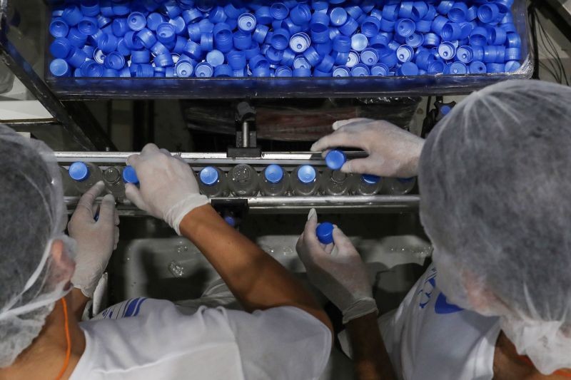 Employees puts caps on bottles of ethanol-based hand sanitizers in a factory in Brazil on March 25, 2020. (REUTERS File Photo)