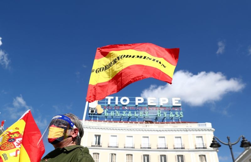 A person wearing a protective face shield and a mask attends a protest against government as Spanish Prime Minister Pedro Sanchez meets Madrid Regional leader Isabel Diaz Ayuso, amid the outbreak of the coronavirus disease (COVID-19) at Puerta del Sol square in Madrid, Spain on September 21, 2020. (REUTERS Photo)