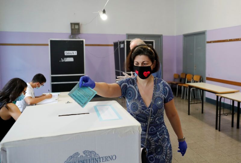 A woman casts her vote on a referendum to sanction a proposed cut in the number of Italian parliamentarians, in Rome, Italy on September 20, 2020. (REUTERS Photo)