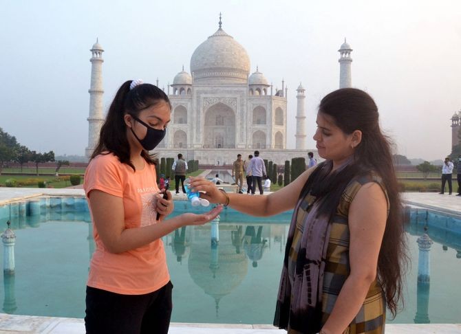 Two girls using hand sanitisers in front of the Taj Mahal after it reopens for the public as part of Unlock 4, in Agra on Monday. Photograph: Yatish Lavania/ANI Photo