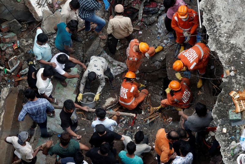 National Disaster Response Force (NDRF) officials search for survivors as people help clear the rubble after a three-storey building collapsed in Bhiwandi, on the outskirts of Mumbai, India, September, 21 2020. (REUTERS Photo)