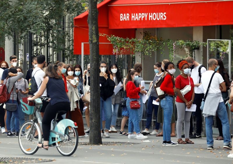 Young people wearing protective face masks stand in front of a cafe in Paris as France reinforces mask-wearing as part of efforts to curb a resurgence of the coronavirus disease (COVID-19) across the country, France on September 3, 2020. (REUTERS Photo)