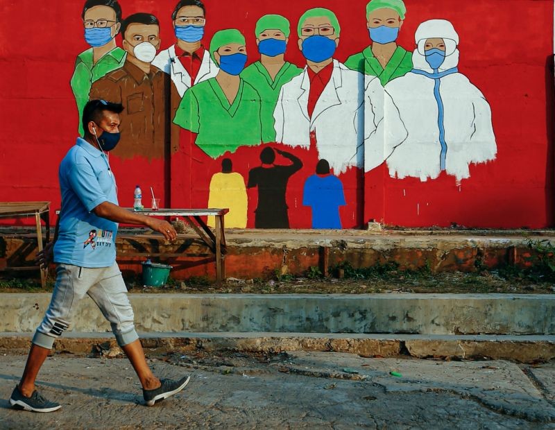 A man wearing a protective face mask passes a mural promoting awareness of the coronavirus disease (COVID-19) outbreak in Jakarta, Indonesia on August 31, 2020. (REUTERS File Photo)