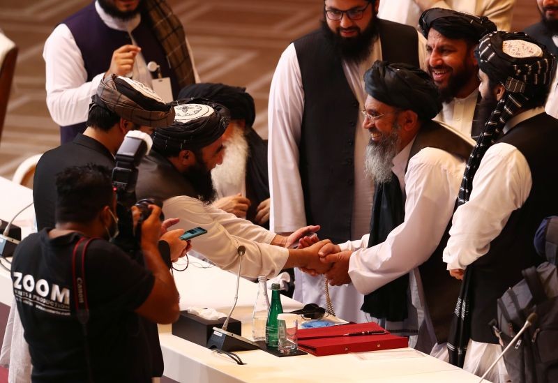 Taliban delegates shake hands during talks between the Afghan government and Taliban insurgents in Doha, Qatar on September 12, 2020. (REUTERS Photo)