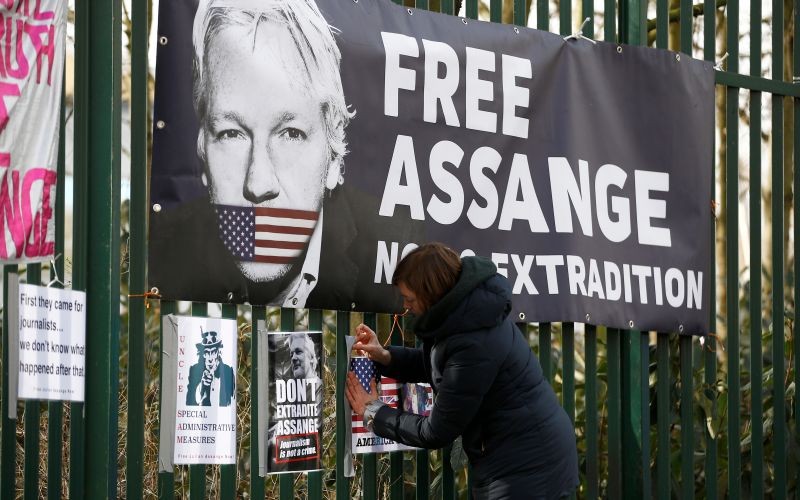A supporter of WikiLeaks founder Julian Assange posts a sign on the Woolwich Crown Court fence, ahead of a hearing to decide whether Assange should be extradited to the United States, in London, Britain on February 25, 2020. (REUTERS File Photo)