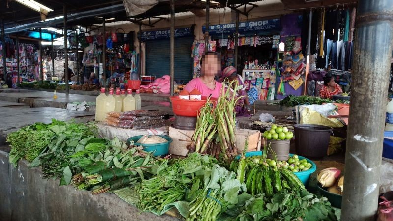 A woman vegetable vendor in Dimapur sits in a market  shed as she waits for customers. (Morung Photo: For representational purpose only.)