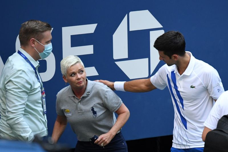 Novak Djokovic of Serbia and a tournament official tend to a linesperson who was struck with a ball by Djokovic against Pablo Carreno Busta of Spain (not pictured) on day seven of the 2020 U.S. Open tennis tournament at USTA Billie Jean King National Tennis Center. Mandatory Credit: Danielle Parhizkaran-USA TODAY Sports