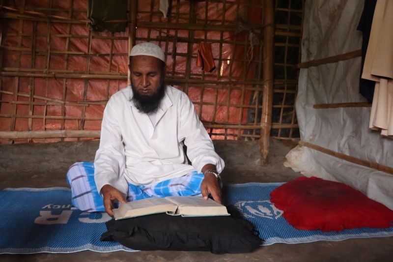 Mohammed Rofiq, a Rohingya refugee, reads Islamic scripture in his home in Kutupalong refugee camp, in Cox's Bazar, Bangladesh on August 8, 2020. (REUTERS File Photo)