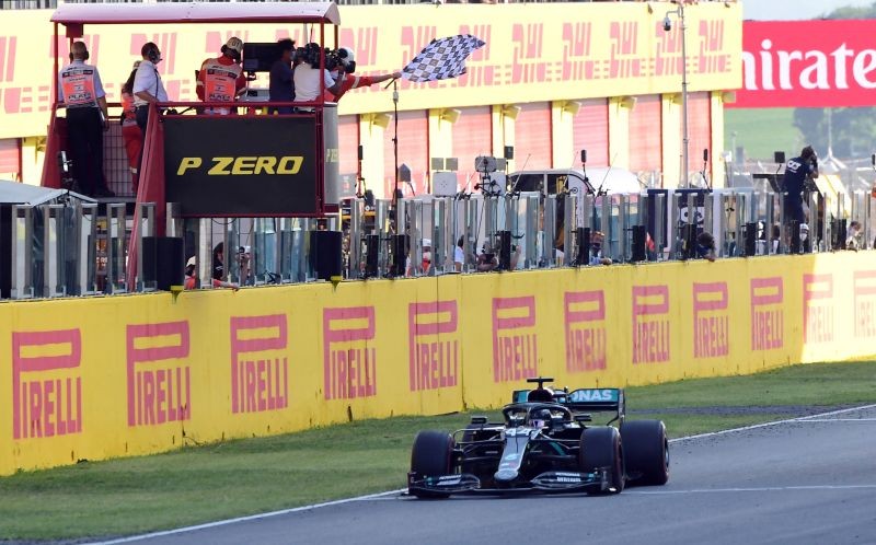 Mercedes' Lewis Hamilton passes the chequered flag to win the race Pool via REUTERS/Jennifer Lorenzini