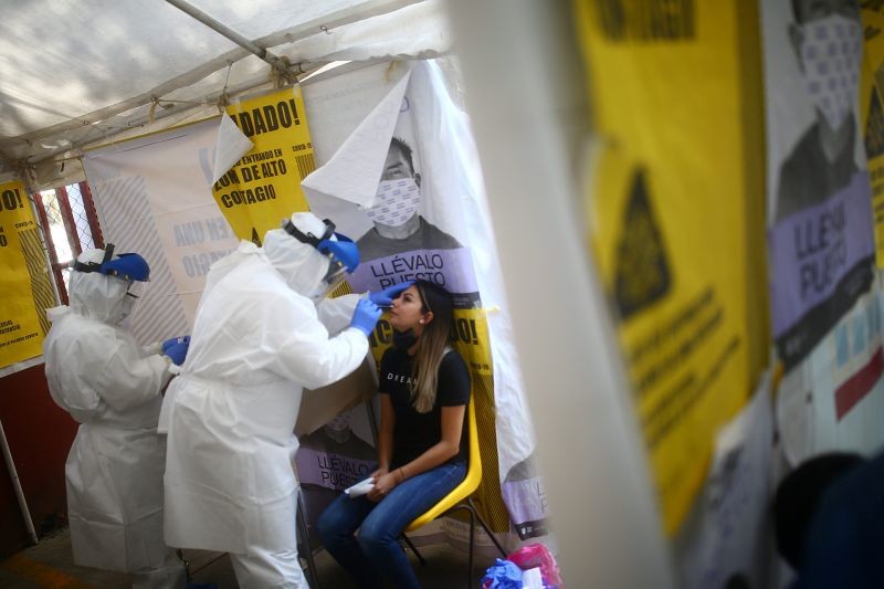 A healthcare worker in personal protective equipment (PPE) collects a sample using a swab from a person at a local health centre to conduct tests for the coronavirus disease (COVID-19), amid the spread of the disease at the Tepito neighborhood in Mexico City, Mexico on September 1, 2020. (REUTERS File Photo)