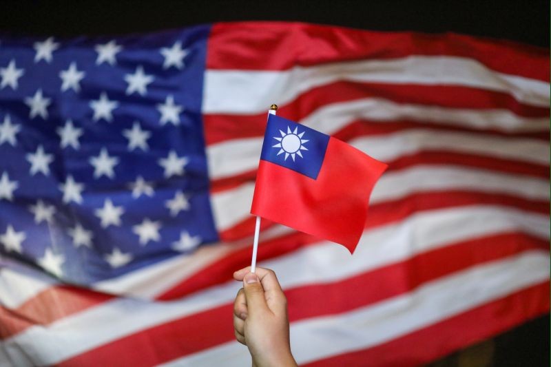 An anti-government protester holds a Taiwan national flag as an U.S. flag flutters in the background during a demonstration to celebrate Taiwan's National Day at the Harbour city in Tsim Sha Tsui district, in Hong Kong, China on October 10, 2019. (REUTERS File Photo)