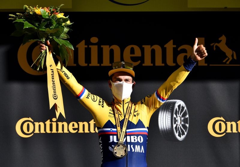 Stage winner Team Jumbo-Visma rider Primoz Roglic of Slovenia celebrates on the podium. Pool via REUTERS/Anne-Christine Poujoulat