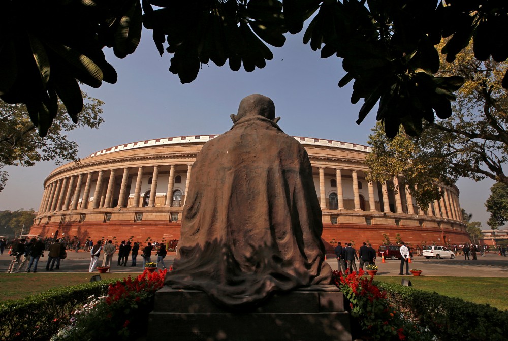 People stand in front of the parliament building in New Delhi, India, February 1, 2018. REUTERS/Adnan Abidi/Files