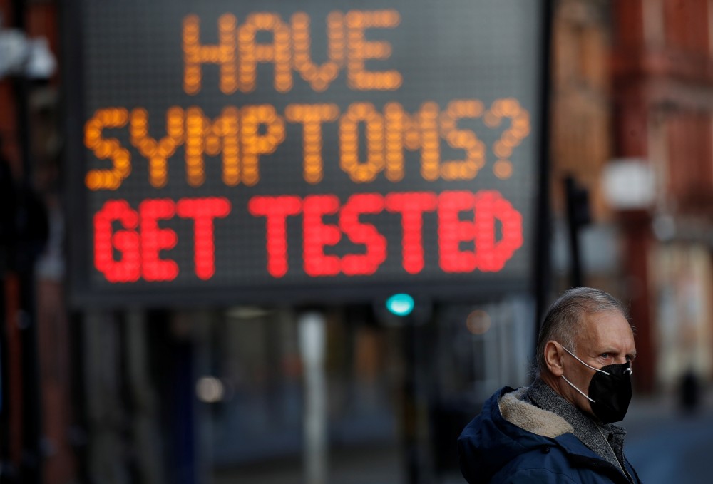 A man wears a mask as he walks past an information board following the outbreak of the coronavirus disease (COVID-19) in Bolton, Britain, September 9, 2020. REUTERS/Phil Noble