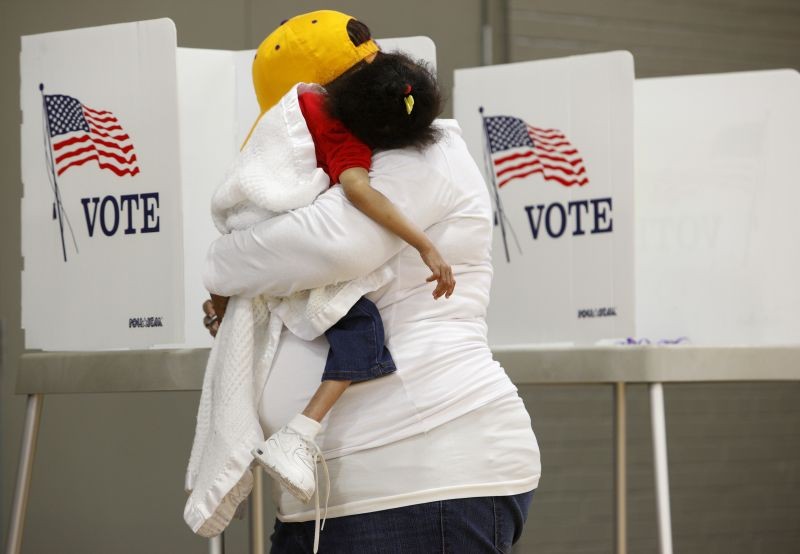 A mother carries her sleeping child while voting during the U.S. general election in Greenville, North Carolina, U.S. on November 8, 2016.  (REUTERS File Photo)