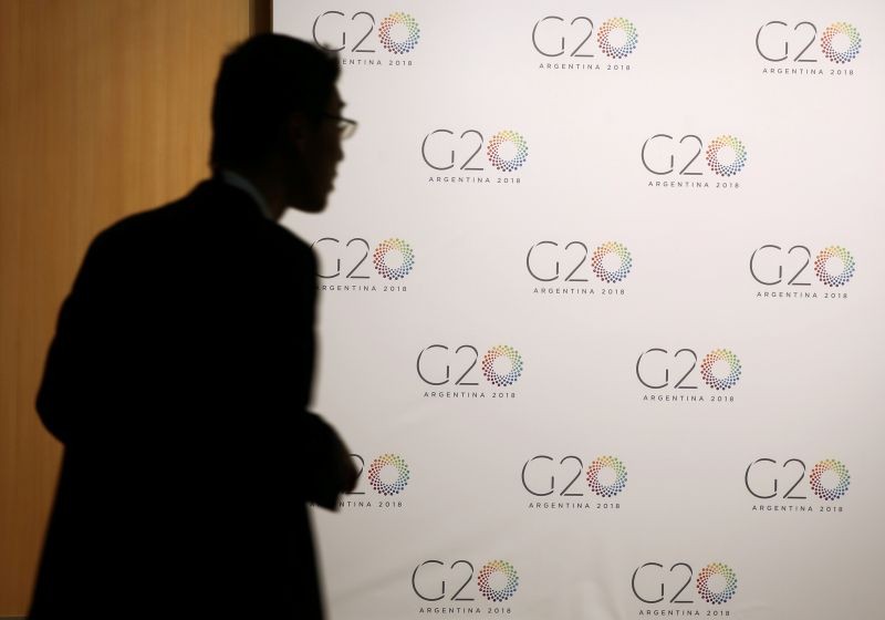 A man stands next to a board with the G20 Meeting of Finance Ministers logo in Buenos Aires, Argentina, March 19, 2018. (REUTERS File Photo)