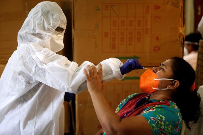 A health worker in personal protective equipment (PPE) collects a swab sample from a woman during a rapid antigen testing campaign for the coronavirus disease (COVID-19) in Mumbai on September 7, 2020. (REUTERS Photo)