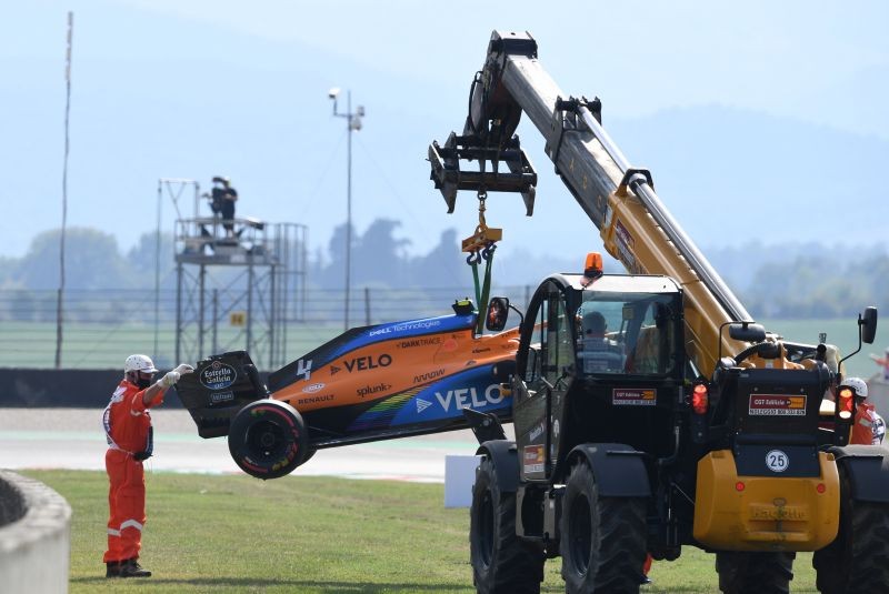 A maintenance team removes the car of McLaren's Lando Norris after a crash during practice Claudio Giovannini/Pool via REUTERS