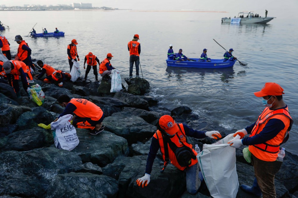 Government workers and volunteers pick up trash along the Manila Bay shore, during the International Coastal Cleanup Day, in Manila, Philippines, September 19, 2020. REUTERS/Eloisa Lopez
