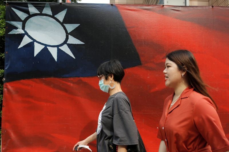 People walk past a Taiwanese flag amid the coronavirus disease (COVID-19) pandemic in Taipei, Taiwan on August 10, 2020. (REUTERS File Photo)