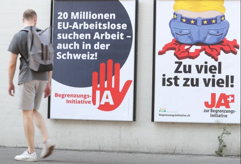 A man walks past posters of the Swiss People's Party (SVP) and of the Komitee Arbeitsplaetze fuer Einheimische schuetzen (committee to protect jobs for locals) against the anti-immigration initiative in Zurich, Switzerland on September 17, 2020. (REUTERS File Photo)