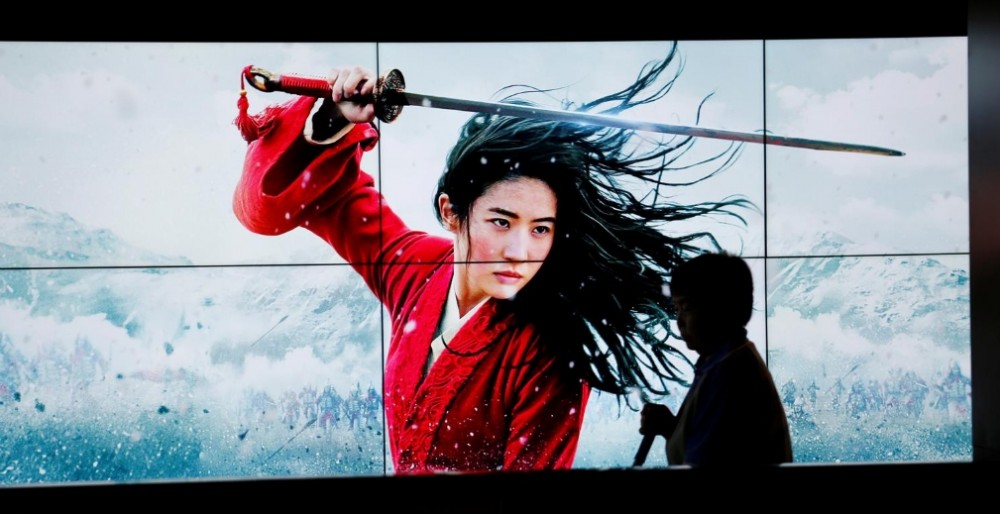 A cleaner walks past screens promoting Disney's movie "Mulan" as the film opens in China, at a cinema in Beijing, China September 11, 2020. REUTERS/Florence Lo