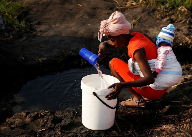 A woman with a baby on her back collects water in Mabvuku, a highly-populated suburb in Harare, Zimbabwe on September 3, 2019. (REUTERS File Photo)