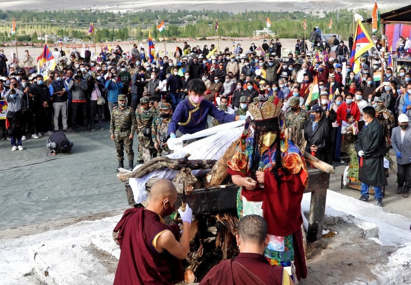 A relative places khadaks, a white piece of silk cloth, over the pyre of Tenzin Nyima, a senior rank Tibetan official from India's Special Frontier Force, during his cremation ceremony in Leh, September 7, 2020. REUTERS/Stringer