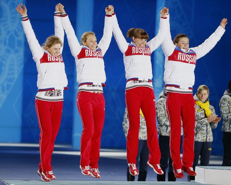 Silver medallists Russia's Yana Romanova, Olga Zaitseva, Ekaterina Shumilova and Olga Vilukhina (L-R) jump on the podium during the victory ceremony for the women's biathlon 4 x 6km event at the 2014 Sochi Winter Olympics February 22, 2014. REUTERS/Shamil Zhumatov/File Photo