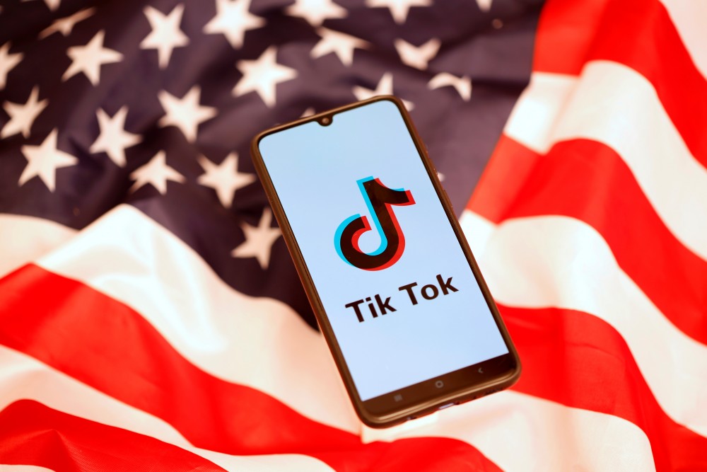 TikTok logo is displayed on the smartphone while standing on the U.S. flag in this illustration picture taken, November 8, 2019. REUTERS/Dado Ruvic/Files