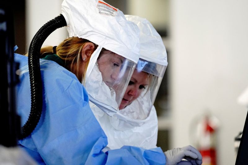 Healthcare workers wearing powered air purifying respirator (PAPR) hoods process COVID-19 test samples at a drive-thru testing site operated by Avera Health inside the former Silverstar Car Wash, as the coronavirus disease (COVID-19) outbreak continues in Sioux Falls, South Dakota, U.S., October 28, 2020. (REUTERS Photo)