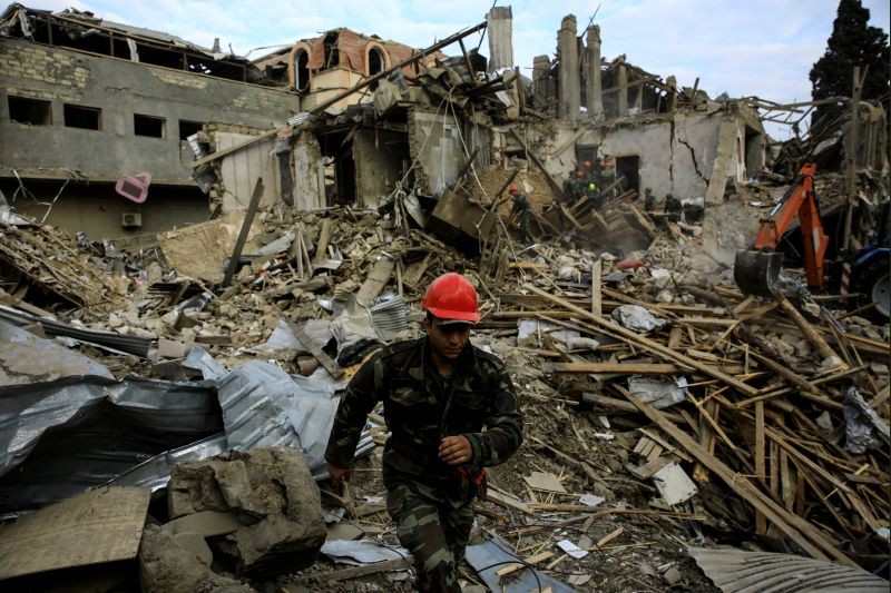 Search and rescue teams work on the blast site hit by a rocket during the fighting over the breakaway region of Nagorno-Karabakh in the city of Ganja, Azerbaijan October 11, 2020. (REUTERS Photo)