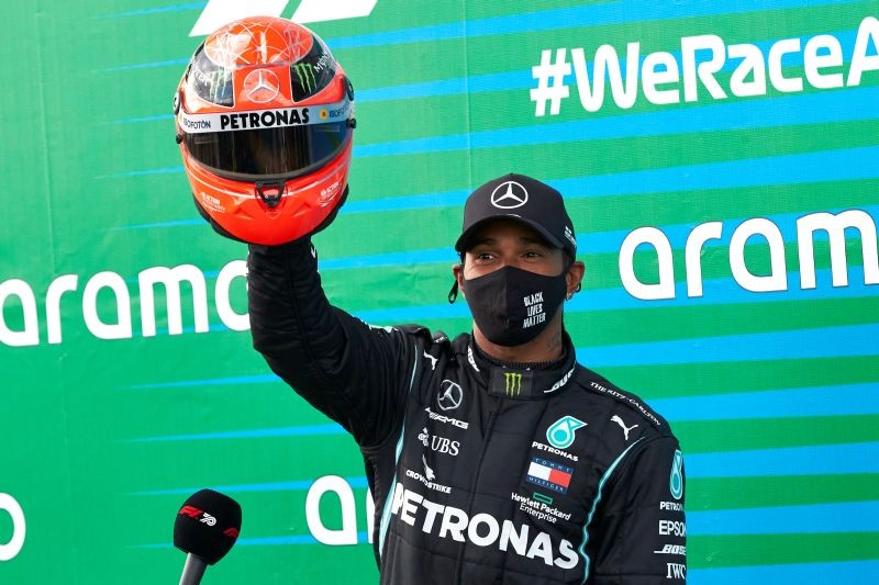 Formula One F1 - Eifel Grand Prix - Nurburgring, Nurburg, Germany - October 11, 2020 Mercedes' Lewis Hamilton poses with a red helmet from Mick Schumacher after winning the race   FIA/Handout via REUTERS