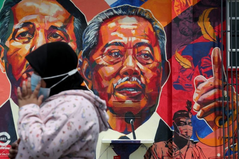 A woman passes by a mural depicting Malaysia's Prime Minister Muhyiddin Yassin in Kuala Lumpur, Malaysia October 27, 2020. (REUTERS Photo)
