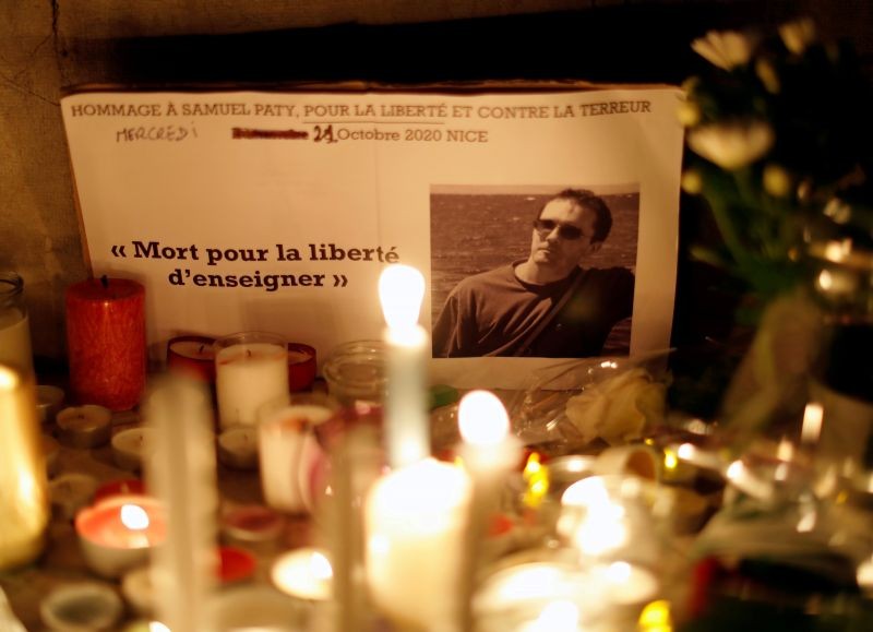 Candles are lit at a makeshift memorial as people gather to pay homage to Samuel Paty, the French teacher who was beheaded on the streets of the Paris suburb of Conflans-Sainte-Honorine, as part of a national tribute, in Nice, France, October 21, 2020. (REUTERS File Photo)