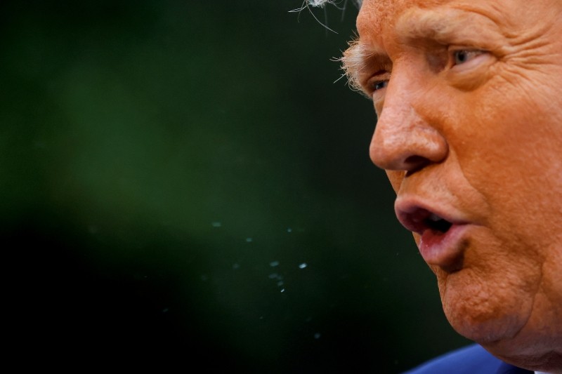 FILE PHOTO: U.S. President Donald Trump speaks to the media on the South Lawn of the White House in Washington, as the droplets of saliva are seen, before his departure on campaign travel to Middletown, Pennsylvania, U.S., September 26, 2020. REUTERS/Carlos Barria/File Photo