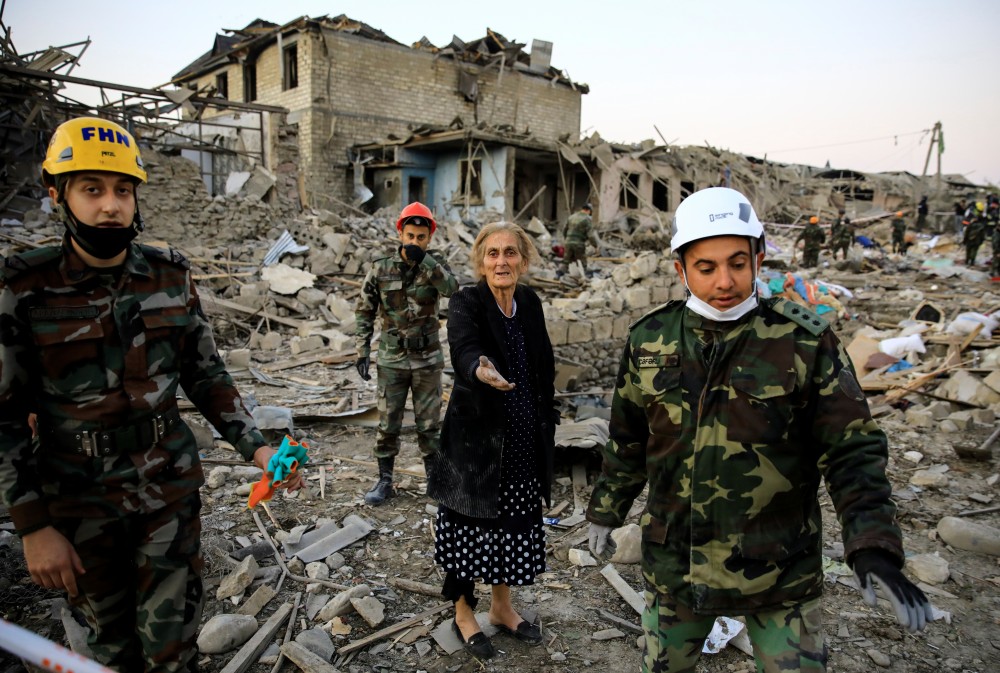 A woman reacts while standing on the ruins of her home as search and rescue teams work on a blast site hit by a rocket during the fighting over the breakaway region of Nagorno-Karabakh, in the city of Ganja, Azerbaijan October 17, 2020. REUTERS/Umit Bektas