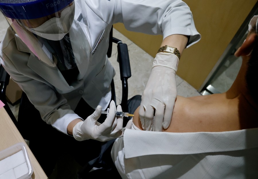 A man gets an influenza vaccine at a branch of the Korea Association of Health Promotion in Seoul, South Korea, October 23, 2020. REUTERS/Kim Hong-Ji/File Photo