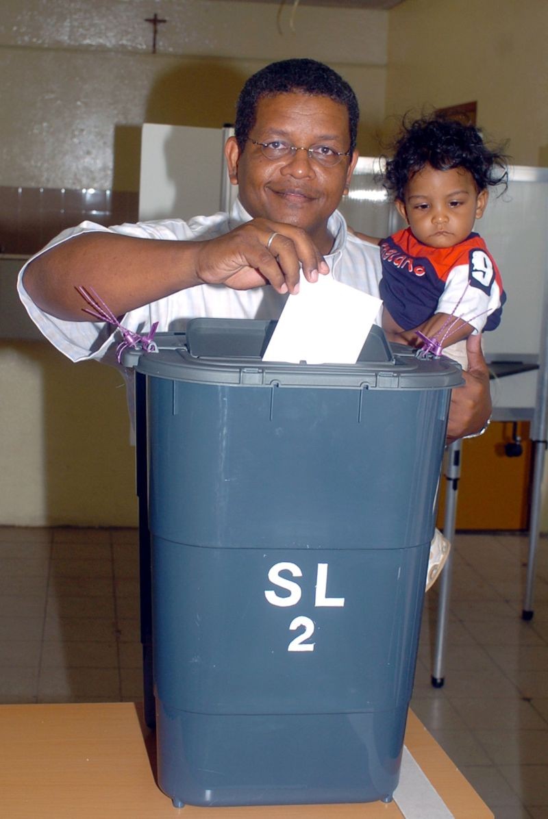 Seychelles presidential candidate and opposition leader Wavel Ramkalawan casts his vote as he holds his nine-month-old son Amos at a polling station in St. Louise constituency, Seychelles, July 30, 2006. (REUTERS File Photo)