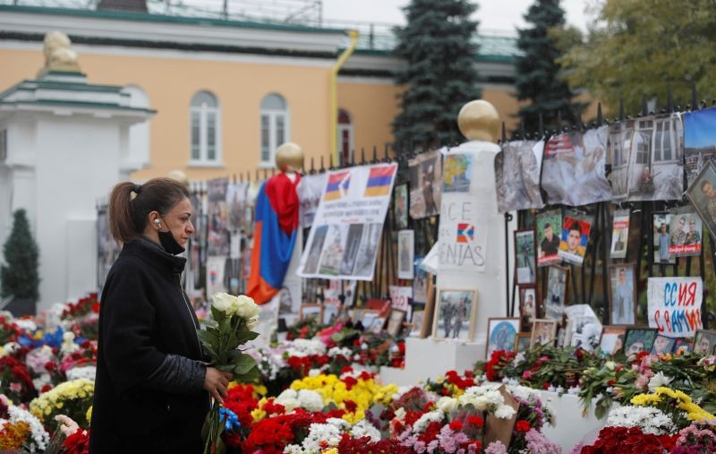 A woman holds flowers while standing next to a makeshift memorial outside the Armenian embassy for people killed during a military conflict over the breakaway region of Nagorno-Karabakh in Moscow, Russia October 20, 2020. (REUTERS Photo)