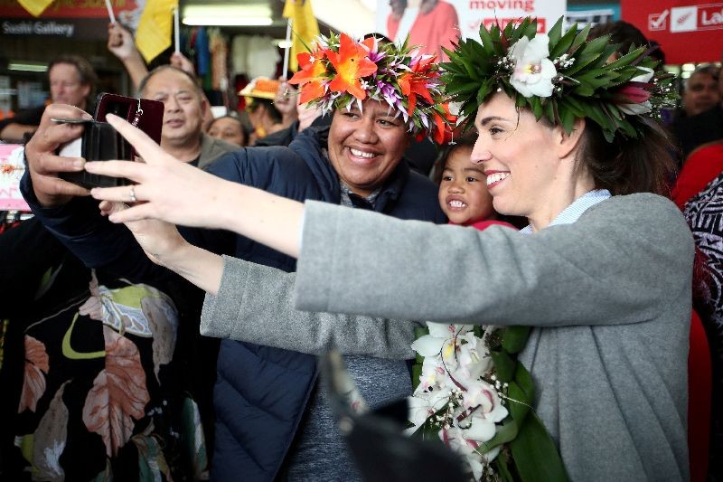 FILE PHOTO: New Zealand's Prime Minister Jacinda Ardern takes pictures with supporters during a campaign outing at Mangere town centre and market in Auckland, New Zealand, October 10, 2020.  REUTERS/Fiona Goodall/File Photo