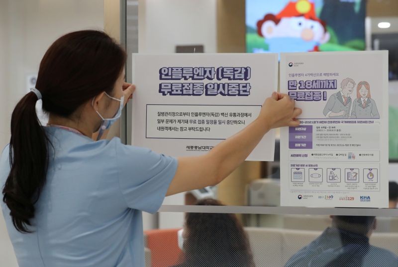 A health worker attaches a notice for suspension of influenza vaccination programs on an entrance of a hospital in Sejong, South Korea, September 22, 2020.   (REUTERS File Photo)