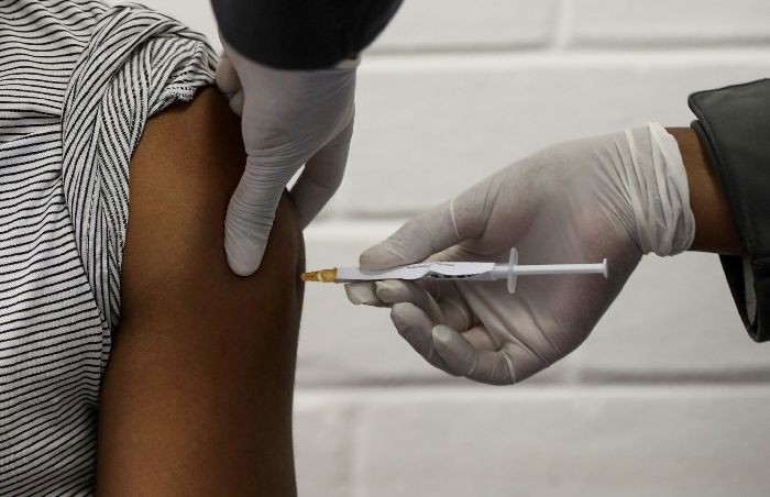 FILE PHOTO: A volunteer receives an injection from a medical worker during the country's first human clinical trial for a potential vaccine against the novel coronavirus, at the Baragwanath hospital in Soweto, South Africa, June 24, 2020. REUTERS/Siphiwe Sibeko/File Photo