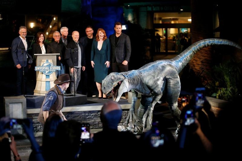 FILE PHOTO: Vice Chairman of Universal Parks & Resorts and President of Universal Creative Mark Woodbury, President and COO of Universal Studios Hollywood Karen Irwin, Vice Chairman of NBCUniversal Ron Meyer, Chairman and CEO of Universal Parks & Resorts Tom Williams, Producer Frank Marshall, Director Colin Trevorrow, Actors Bryce Dallas Howard and Chris Pratt and the velociraptor character named Blue pose at the "Jurassic World - The Ride" grand opening celebration at Universal Studios Hollywood theme park in Universal City, California, U.S., July 22, 2019. (Reuters File Photo)