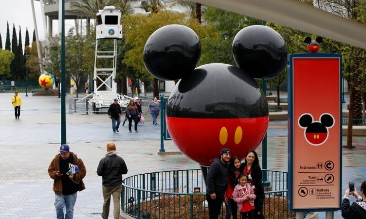 A family poses for a photo at Disneyland theme park in Anaheim, California, U.S., March 13, 2020. REUTERS/Mario Anzuoni/Files